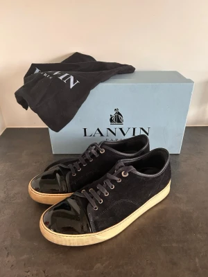 Lanvin skor - Väldigt fräscha Lanvins i storlek 42. Skicket på lanvinsen är 8/10 de ända de hade behövt är en tvätt. Som ni ser på bilderna är de ej några synliga defekter, glansen är väldigt fin. De som fås med är box, dustbag och extra snören.