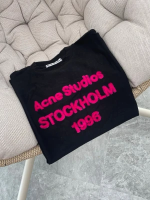 Acne Studios T-Shirt - Supersnygg Acne t-shirt till tjej med rosa fluffig text. Storlek S. Passformen är oversized/baggy. Alltså en avslappnad luftig passform, passar därför också större storlek. Perfekt att matcha till trendiga outfits. Skickar snabbt!