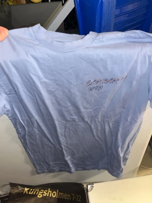 Ljusblå Carhartt WIP Gelato t-shirt - Säljer en ljusblå t-shirt från Carhartt WIP med trycket 'Gelato' och färgglada glassmotiv på ryggen. Nästan oanvänd