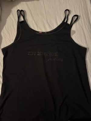 svart linne från Diesel  - tryck inte på köp direkt eftersom jag har den upplagd på andra appar också! :) säljer ett svart linne med tunna axelband och logga framtill. enkel och stilren modell som passar med allt! materialet känns mjukt och följsamt. fint begagnat skick! Inga hål eller fläckar, den är bara nopprig men det är inget som stör. står XXL men är liten i storleken, passar som L/M beroende på passform. 450kr, men priset kan diskuteras! hör av dig om du har fler funderingar💗