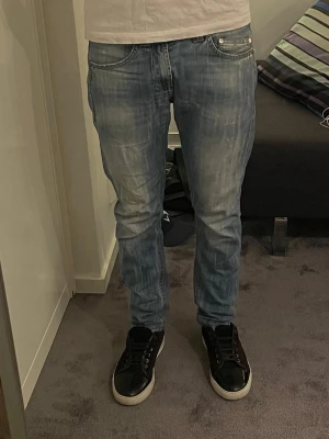 Ljusblå slim  Dondup  - Säljer ett par ljusblå dondups med snygg tvätt och detaljer. Storlek 29/30. Modellen är 175cm lång