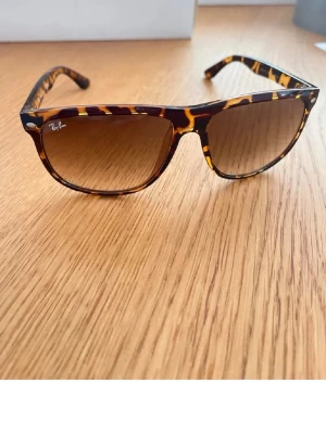 Rayban boyfriend - Snygga solglasögon från Ray-Ban med klassisk  trendig turtleskalad båge i bruna och gula toner. Glasen är lätt tonade i brunt och bågarna har små silvriga detaljer vid hörnen. Perfekta för soliga dagar! Köpt på marknad utomlands