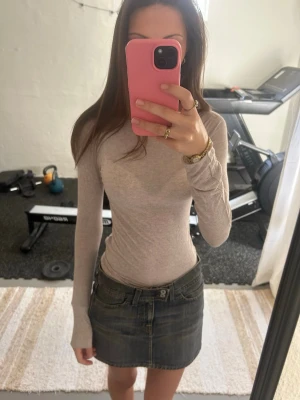 Intimisimi Ljusbeige långärmad topp - Säljer en ljusbeige, tight långärmad topp med rund hals. Toppen är enkel och stilren, perfekt att matcha med olika outfits. Materialet känns mjukt och stretchigt, vilket ger en bekväm passform. Passar dig som gillar en clean och minimalistisk look.