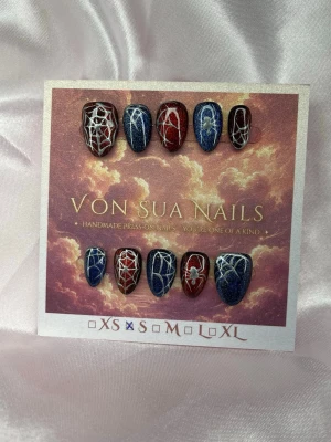 2099 (S);ExtraShortAlmond  - Handgjorda unika press-on naglar i blått och rött med silvriga spindelnätsmotiv och cateyeeffekt. Extra kort mandel form. Perfekt för dig som vill ha en unik och kreativ nageldesign inspirerad av spiderman 🕷️S: 15 mm, 11,5 mm, 12 mm, 11 mm, 9 mm 