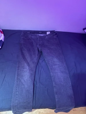 Svarta jeans från Jack & Jones - Snygga svarta jeans från Jack & Jones med klassisk femficksdesign och raka ben. Jeansen har en stilren look och är tillverkade i ett mjukt denimtyg som passar perfekt till många olika outfits.