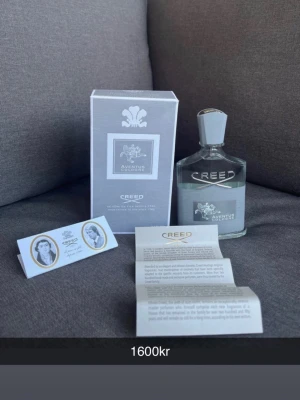 Creed Aventus Cologne EdP 100ml - Lyxig parfym från Creed, Aventus Cologne EdP 100ml. Flaskan är genomskinlig med silverfärgad kork och detaljer. Kommer med originalkartong och informationsblad. Doften är elegant och modern, perfekt för dig som gillar exklusiva parfymer.