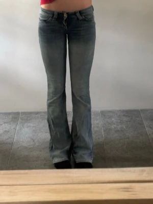 Blå bootcut jeans med slitningar - Säljer ett par blåa  bootcut jeans från weekday. Lappen på byxan har åkt av och det är även lite söndrigt längst ner på byxan. Säljer pågrund av att dom blivit försmå till mig. Pris kan diskuteras.