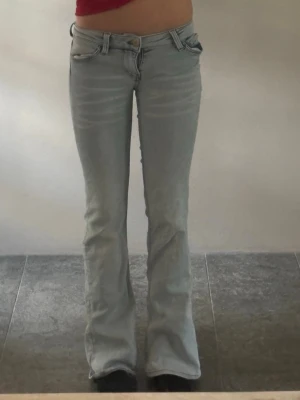 Ljusblå bootcut jeans - Säljer ett par ljusblå låg midjade bootcut jeans. Inte andvänt så många gånger men lappen på byxan är lite sönder men syns knappt. Pris kan diskuteras.