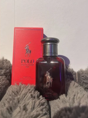 Polo Red Parfum från Ralph Lauren - Polo Red Parfum från Ralph Lauren i en elegant röd glasflaska med silverfärgat lock och klassisk logga framtill. Kommer i en snygg röd kartong med silverdetaljer. Doften är intensiv och maskulin, perfekt för dig som vill sticka ut. Nypris 600 