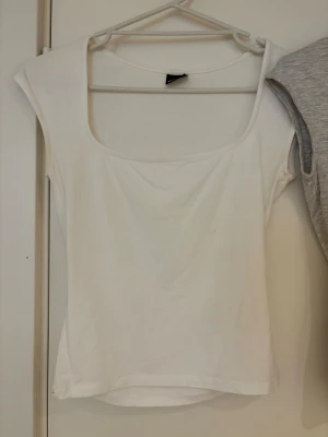 Basic toppar  - Säljer två stilrena toppar, både vit och ljusgrå, denna annonsen är endast för den vita toppen, om du är ute efter den gråa så finns den också i min profil. Mjukt material som känns skönt mot huden, oanvända💕