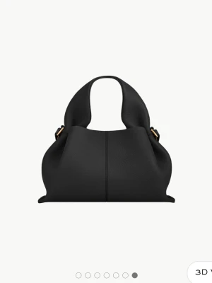 Polene Paris väska svart  - Svart handväska i mjuk skinnimitation med rundad form o breda handtag. Den har guldfärgade metalldetaljer vid handtagen och design som passar till alla olika stilar. Den är från polene Paris och har använts fåtal gånger. Mycket bra skick! Numéro Neuf Mini heter modellen