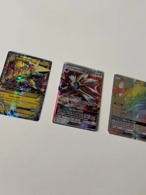 Solgaleo GX Pokémonkort, EX Manectric och GX Necrozoma. - Säljer ett paket med 3 Pokémonkort: ⚡ M Manectric EX ☀️ Solgaleo GX 🌌 Necrozma GX Korten säljs tillsammans och är i bra skick. Se bilderna för egen bedömning av skick. Skickas väl skyddat så att korten kommer fram säkert. Hör gärna av dig om du har frågor eller vill se fler bilder.