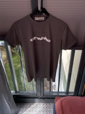 Grå Off-White t-shirt med tryck - Snygg grå t-shirt från Off-White med stort vitt logotryck på bröstet och ikoniskt svart grafiskt motiv på ryggen. Klassisk passform och rund halsringning. Perfekt för dig som gillar streetwear och vill sticka ut.