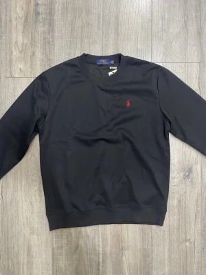 Polo Ralph Lauren tröja - Riktigt snygg svart långärmad tröja från Polo Ralph Lauren. Storlek M. Aldrig använd. Hör av er vid fler frågor!🙌