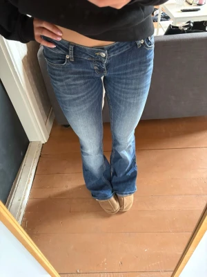 Blå bootcut jeans med låg midja - Blaze jeans från lager 157! De är knappt använda. Har tagit av den bruna lappen som egentligen sitter där bak pga att jag tycker de ser snyggare ut så!