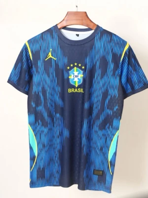 Blå Brasilien fotbollströja - Säljer en blå fotbollströja med Brasilien CBF-logga och gula detaljer. Tröjan har ett mönster i olika blå nyanser, rund hals och korta ärmar. Perfekt för dig som vill stötta Brasilien på match eller träning.
