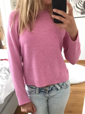 Rosa stickad tröja - Säljer en söt rosa stickad tröja med rund hals och långa ärmar. Tröjan har en enkel, rak passform och är jätte skön. Säljer för att den har blivit för liten