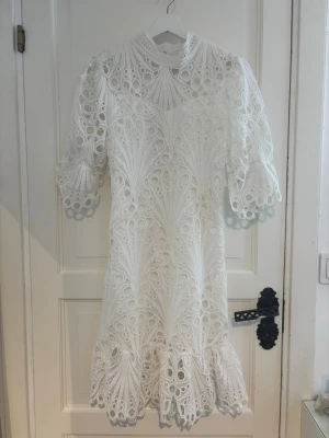Vit spetsklänning med volang - Superfin vit klänning i spets perfekt för de som ska ta studenten eller bara vill ha en fin vit klänning. Köpt second hand så vet tyvärr ej märket 
