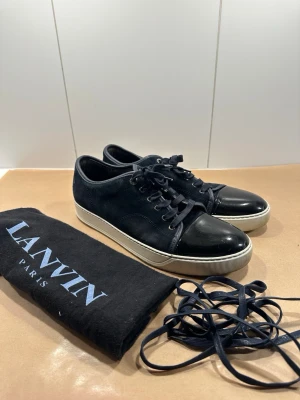 Lanvin skor - Sjukt snygga lanvin skor till salu är, perfekta för sommaren! Skorna är storlek 9 vilket tyder på storlek 43! Grymt skick, ser exakt ut som bilderna så avgör själ! Färgen är navy blue och extra skosnören samt dustbag medföljer! Skriv gärna vid fler frågor🙏