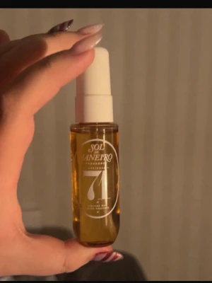 Sol de Janeiro parfym mist - En liten sprayflaska med Sol de Janeiro parfym mist. Flaskan är genomskinlig med guldfärgad vätska och har en vit spraykork. Perfekt att ha med i väskan för en fräsch doft när som helst.