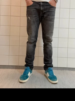 Svarta Replay jeans med slim fit - Säljer ett par svarta Replay jeans i slim fit-modell. Jeansen har en snygg tvätt med lätt slitning på låret och klassiska fem fickor. Materialet är mjukt och stretchigt för extra komfort. Perfekta för dig som gillar en modern och avslappnad stil. L32 hör av dig vid minsta fundering 