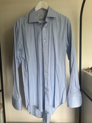 Ljusblå klassisk skjorta - Säljer en stilren ljusblå skjorta med klassisk krage och långa ärmar. Perfekt för dig som gillar en clean och enkel look.