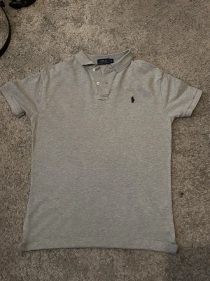 Grå pikétröja från Polo Ralph Lauren - Säljer en grå pikétröja från Polo Ralph Lauren i storlek S. 