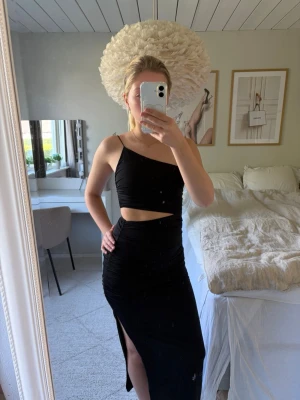 Svart oneshoulder långklänning - Säljer en superfin svart långklänning från Zara i storlek S🖤. Klänningen har en one-shoulder-design, ett band över ena axeln och är öppen vid midjan. Den sitter tight mot kroppen och har en hög slits på vänster sida. Perfekt till fest eller när du vill ha en stilren och trendig look!✨ Endast testad, men prislappen är tyvärr inte kvar. Nypris 500kr.