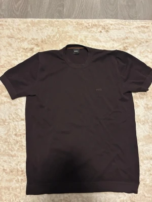 Svart t-shirt från BOSS - Snygg svart t-shirt från BOSS med diskret logga på bröstet. Klassisk rund halsringning och korta ärmar. Perfekt basplagg i garderoben och passar till det mesta. Tillverkad i mjuk bomull för skön känsla.