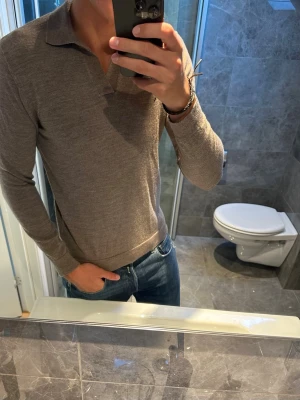 Brun långärmad piké från A Day's March - Säljer en stilren brun långärmad piké från A Day's March. Tröjan har en klassisk krage och är tillverkad i ett tunt, mjukt material som passar perfekt till jeans. Jag på bilden är 188cm och den är för liten på mig. Annars superbra skick och inga defekter. Hör av er vid fler frågor;)
