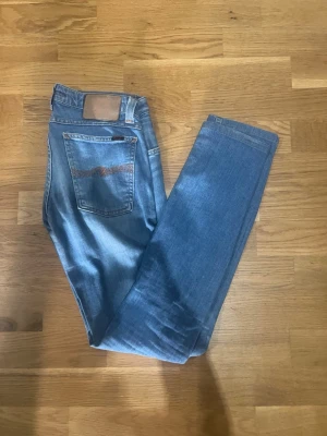 Nudie jeans  - Snygga nudie  jeans i klassisk modell med rak passform och fem fickor. Jeansen har en ljus tvätt och detaljerad söm på bakfickan. Perfekta till en avslappnad stil och tillverkade i denim.