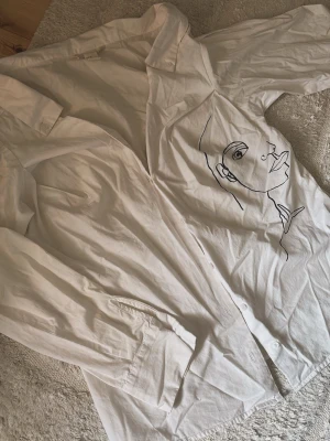 Vit skjorta med konstnärligt tryck - Superfin damskjorta från H&M, skjortan har storlek M men skulle säga att den mer sitter som en S! 