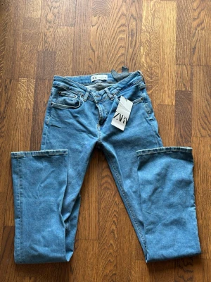 Blå raka jeans från ZARA - Snygga blå jeans från ZARA med klassisk femficksmodell och raka ben. Jeansen har normal midja och är gjorda i ett mjukt denimtyg av bomull. Perfekta för dig som gillar en enkel och tidlös look.