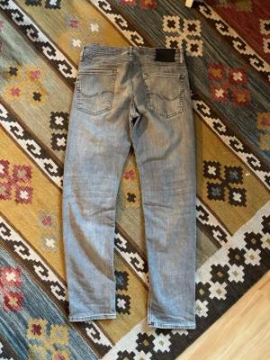 Ljusblå slim fit jeans - Säljer ett par ljusblå slim fit jeans med klassisk femficksdesign och snygga slitningar framtill. Jeansen har normal midja och raka ben, perfekta för en avslappnad och trendig look. Passar till det mesta och är ett måste i garderoben. Strl 31/32 passar även andra storlekar som e nära denna