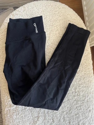 Dfyne impact leggings - Snygga svarta seamless leggings från Dfyne. Stretchigt material som sitter skönt och formar sig efter kroppen. Perfekta för träning eller chill. Diskret logga på linningen. Klassisk och enkel design.