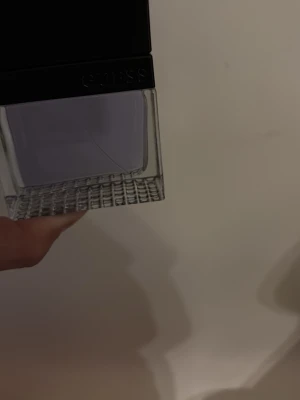 Lila parfymflaska från GUESS - Snygg parfym från GUESS i en rektangulär glasflaska med lila doftvätska. Flaskan har ett rutmönstrat glas i botten och svart lock med GUESS-logga. Perfekt för dig som gillar stilrena och moderna designer.