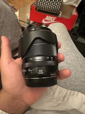 Fujifilm XF 18-55mm zoomobjektiv - Säljer ett svart Fujifilm XF 18-55mm f/2.8-4 zoomobjektiv. Objektivet har en robust metallkonstruktion, tydliga markeringar för brännvidd och bländare samt en praktisk zoomring. Perfekt för dig som vill ha ett allroundobjektiv till din Fujifilm-kamera.