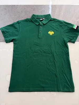 Grön pikétröja Syrien T-shirt - Hej! Jag säljer en disgne t shirt som jag gjorde själv, kvaliten på t shirten är väldigt bra med syriska symbolen, väldigt stilren, finns i alla storlekar S-XXL  även i färgen svart, skriv gärna vid intresse ❤️💯