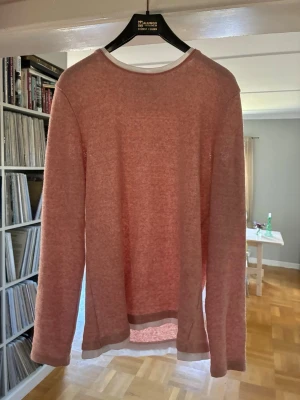 Ljusrosa longsleeve  - En enkel och stilren ljusrosa stickad tröja med rund halsringning och långa ärmar. Tröjan har en mjuk och tunn stickning, perfekt för lager på lager. Passar dig som gillar en avslappnad och clean look.