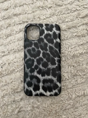 iPhone 11Leopardmönstrat mobilskal svart/vitt - Snyggt mobilskal med leopardmönster i svart och vitt. Skalet är gjort i ett tåligt plastmaterial och har en matt finish. Passar perfekt för dig som vill ha ett unikt och trendigt skydd till din mobil.