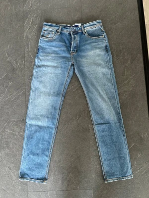 Ljusblå raka jeans / Jacob Cohën - Säljer ett par ljusblå jeans med klassisk femficksdesign och raka ben. Jeansen har en snygg tvättad look och detaljer som kontrastsömmar och bälteshällor. Perfekta för en avslappnad stil och passar till det mesta i garderoben.