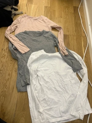 3-pack långärmade toppar H&M, name it - Säljer ett 3-pack långärmade toppar 2 från H&M och 1 från name it, går att köpa för 10kr st.         Vit tröja: 146/152.                                                   Grå tröja: 134/140.                                                Ljus rosa tröja: 134/140. 