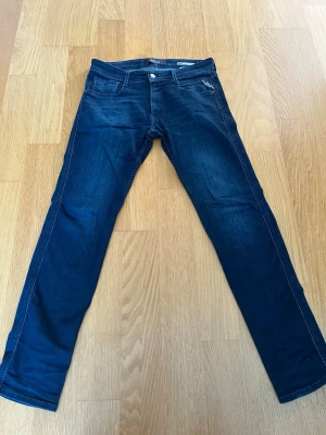 Replay anbass - Marinblå replay jeans i modellen anbass. Jeansen är i mycket bra skick och har endast några få tecken på användning (slitningar på bakfickorna, se bild 3 och 4), men inget man tänker på. Storlek W30 L32, hör av er vid frågor.