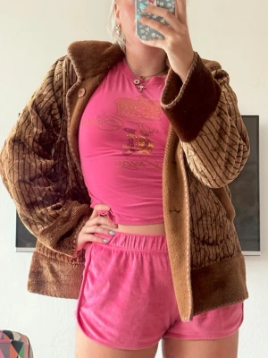 Cool unik vintage pälsjacka - Säljer en brun pälsjacka i vintage-stil med snyggt rutmönster och breda muddar. Jackan har en oversized passform, stora fickor och stängs med knappar framtill. Perfekt för dig som vill ha en unik och varm jacka/fleece/tröja med retrovibbar.