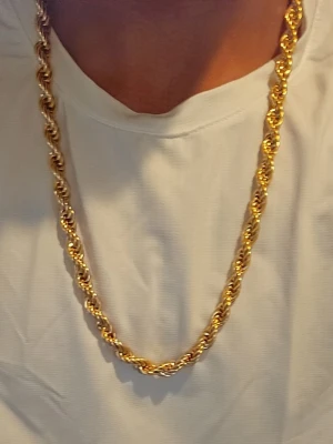 8mm 18k Guldplaterad cordellhalsband - Säljer ett snyggt halsband i guldfärg med tvinnad kedja som ger en riktigt fet look. Halsbandet har en klassisk rope chain-design och är tillverkat i metall med blank finish. Perfekt för dig som vill sticka ut och addera lite extra bling till din stil.