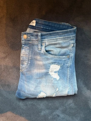 Jack & Jones jeans  - Säljer ett par jack & jones jeans i storlek 30/32! Jeansen är i gott skick och har slitningar men inga hål rakt igenom! Skick 9/10 | storlek:30/32 