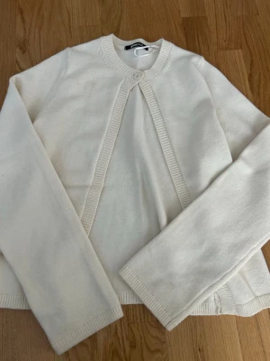 Kofta Gina tricot  - Säljer denna kofta från Gina tricot som endast använts vid ett tillfälle men som fått en liten fläck som inte syns så mycket,(se bid 2) men som jag ej provat få bort. 