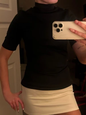 Kort vit kjol i enkel design - Snygg kort vit kjol med rak passform och minimalistisk look. Perfekt att matcha med olika toppar för en trendig stil. Kjolen har en slät yta och är lätt att bära till många tillfällen.