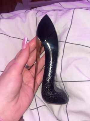 Carolina Herrerar  - Flaskan är svart med glittereffekt och har en guldfärgad klack. Perfekt som dekoration eller till din parfymkollektion. Från Carolina Herrera 