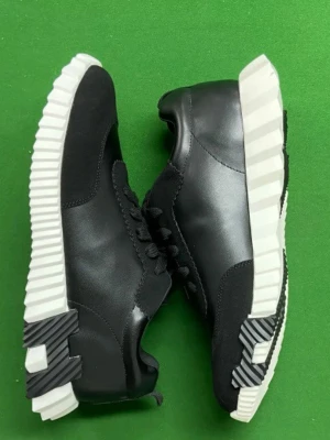 Svarta sneakers med vit sula - Stilrena svarta sneakers med chunky vit sula och svarta detaljer. Skorna har en mix av slätt och mockaliknande material samt svarta skosnören. Sulan har ett randigt mönster baktill och framtill för en cool kontrast.